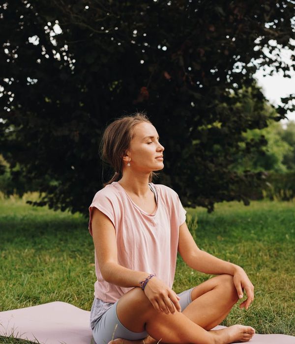 A person sitting in a meditative yoga pose, looking serene and focused.